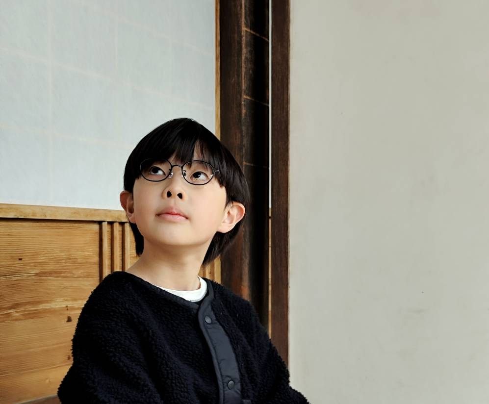 日本家屋でメガネをかけて座るお子さま